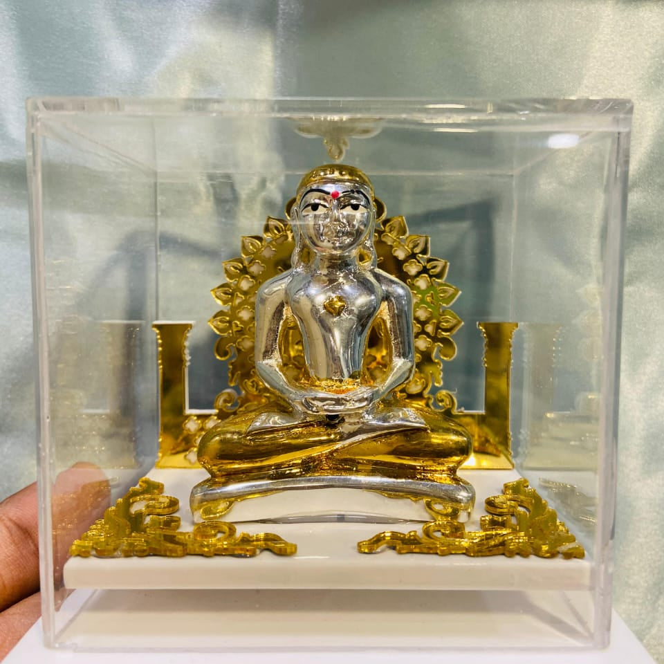 Decorative figure of a seated figure with gold accents in a clear box.