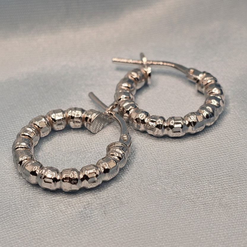 Silver hoop earrings with beaded design on a gray background