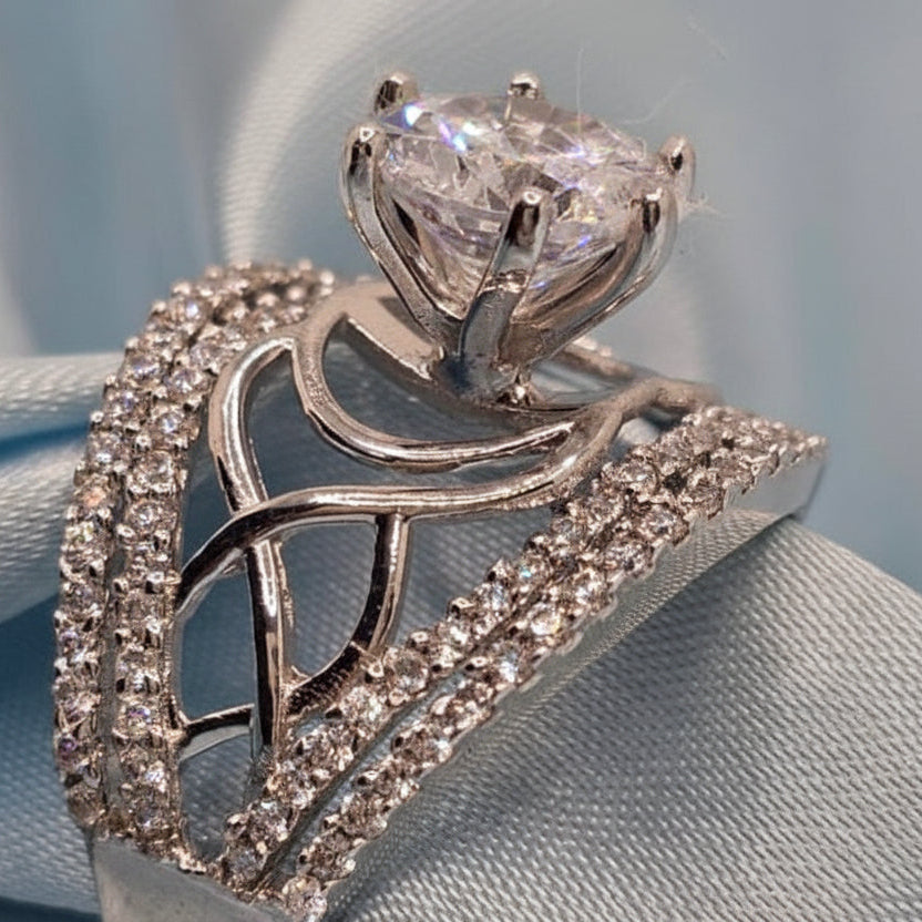 Silver ring with diamond accents on a light blue fabric background