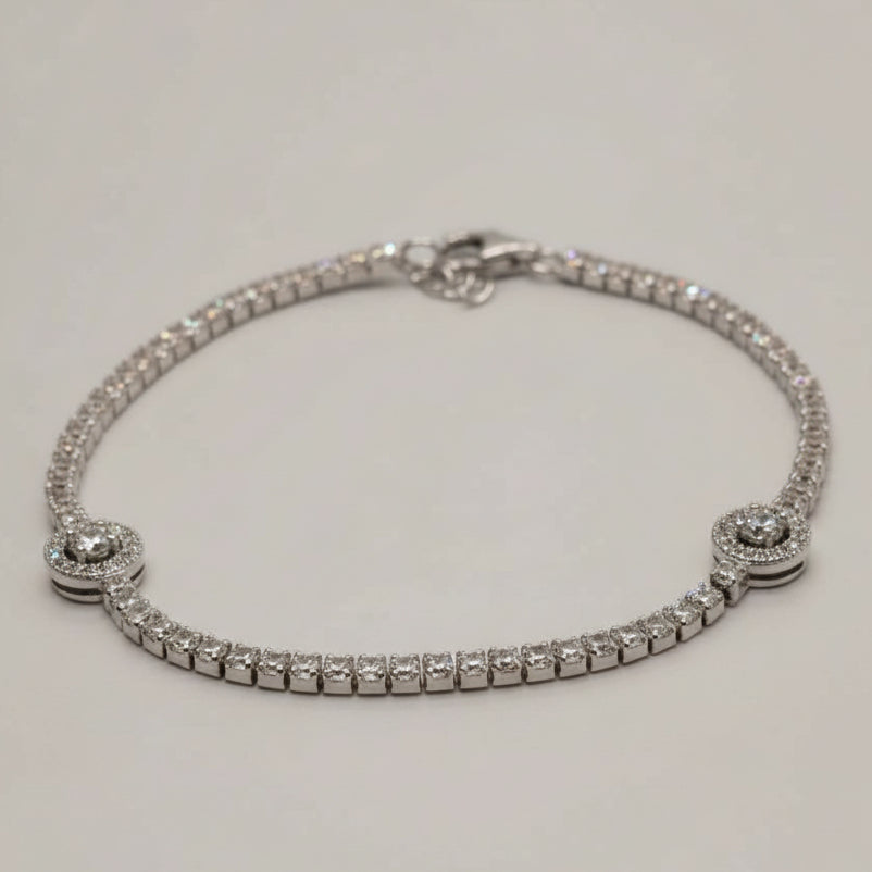Silver bracelet with diamond-like stones on a light gray background