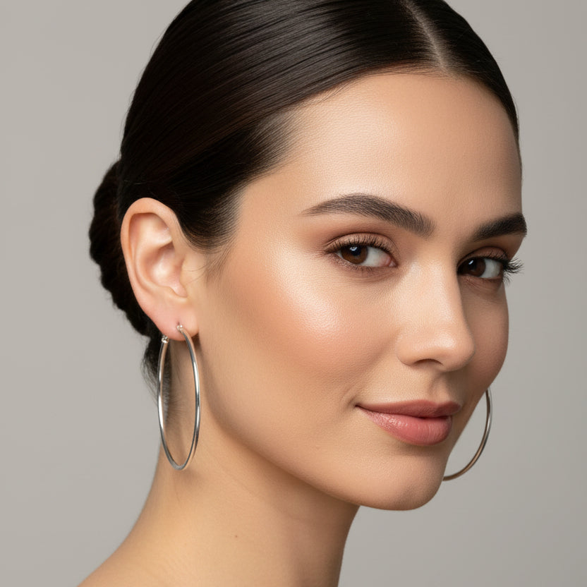 Silver hoop earrings on a light gray fabric background