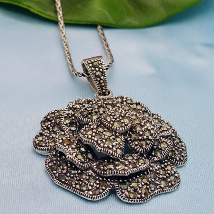Silver pendant with gemstones on a light blue background