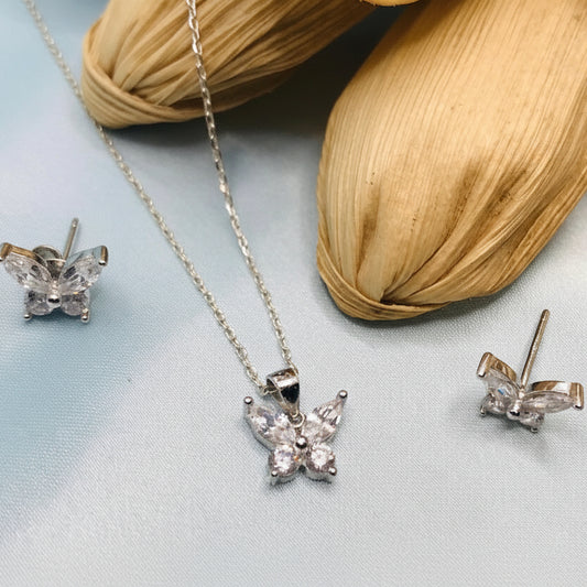 Jewelry set with necklace and earrings on a light blue fabric background