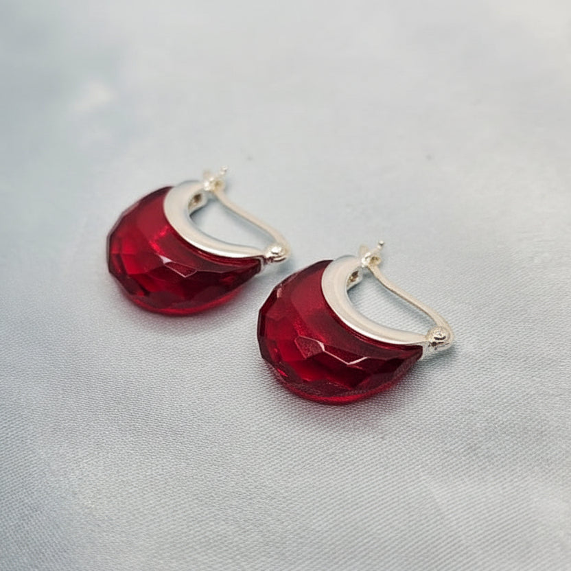 Red earrings on a light gray background