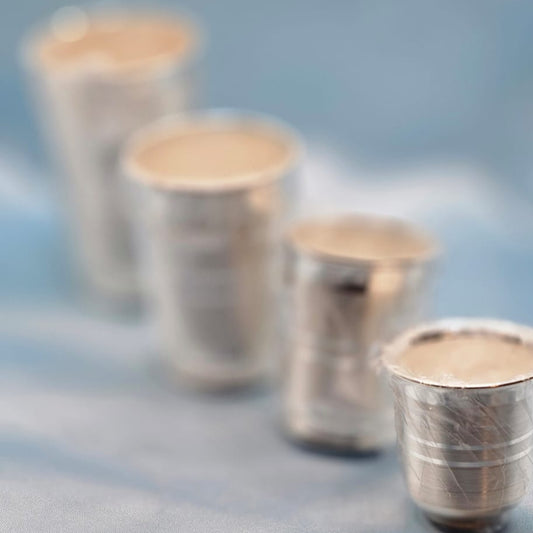 Set of silver shot glasses on a textured surface