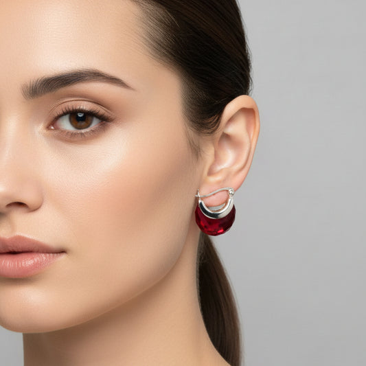 Red hoop earrings with silver hooks on a gray background