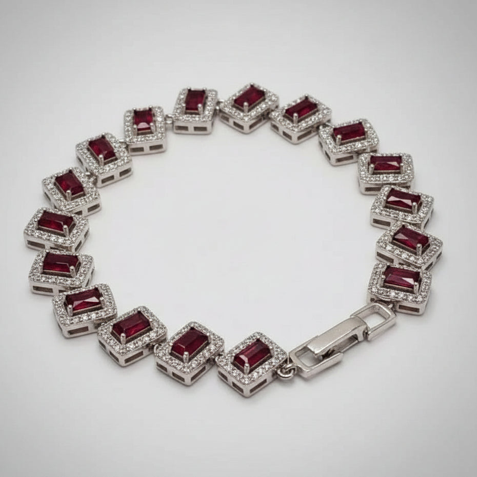 Silver bracelet with red gemstones on a gray background