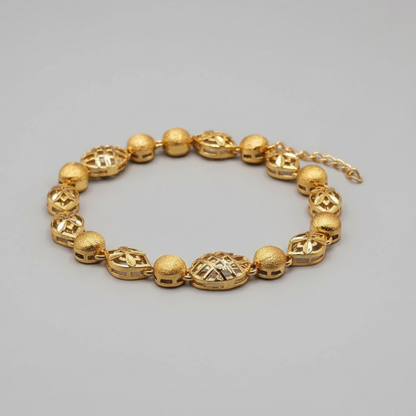Gold bracelet on a light blue fabric background