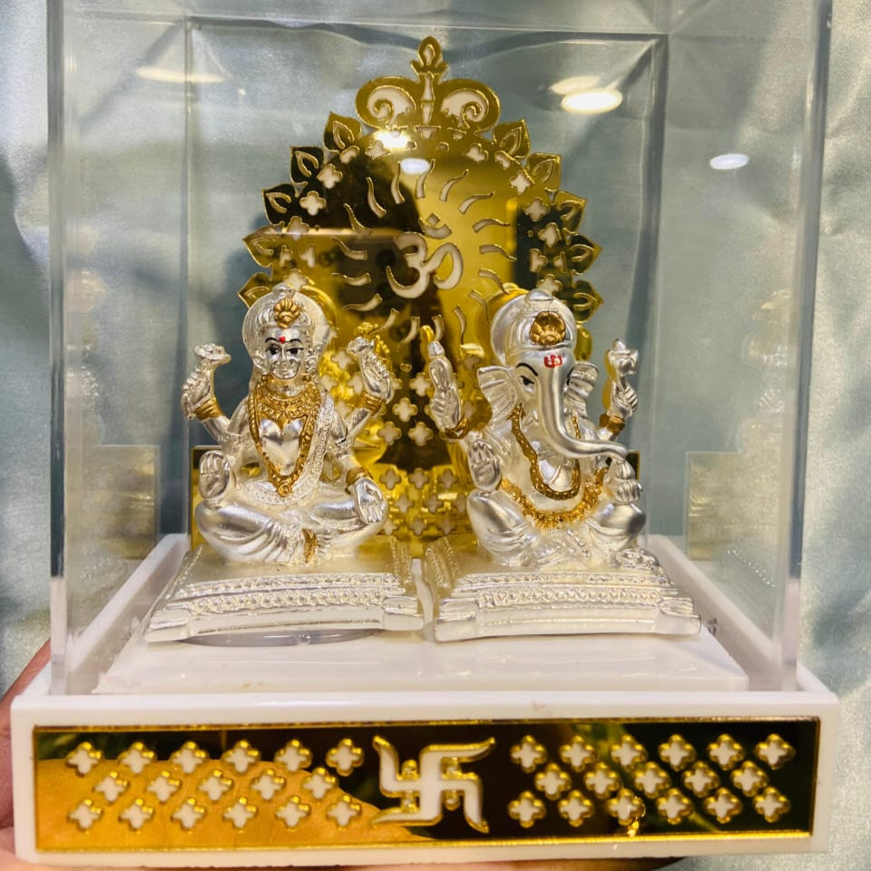 Decorative item with gold and silver statues on a clear base with a black and gold border.