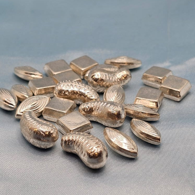 Collection of silver jewelry components on a light blue fabric background