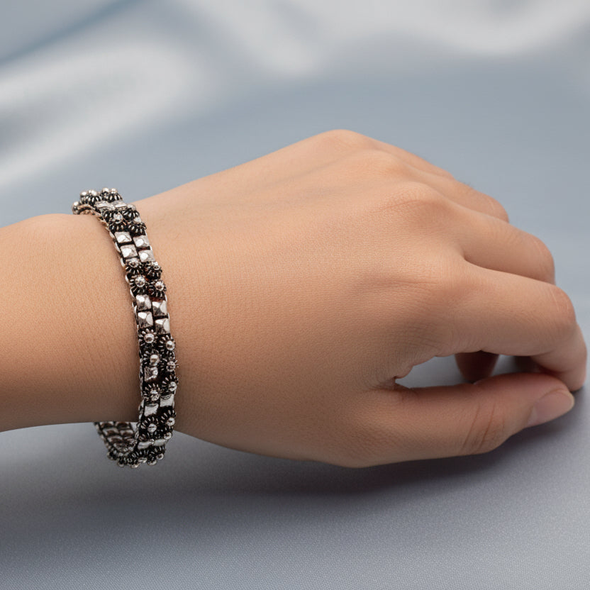 Silver and black beaded necklace on a gray background