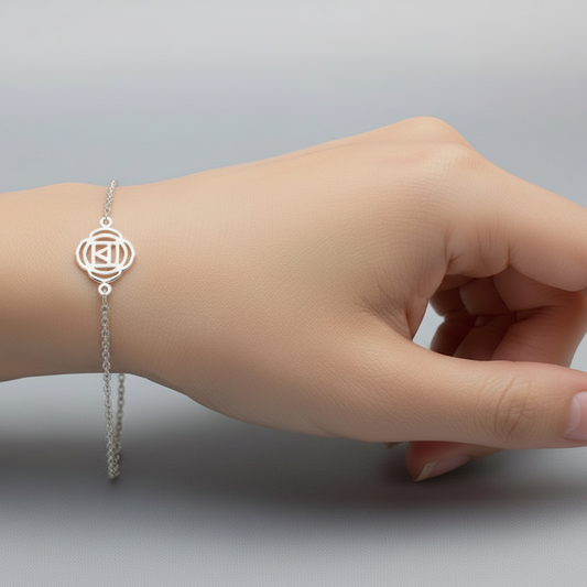 Silver bracelet on a person's wrist against a gray background