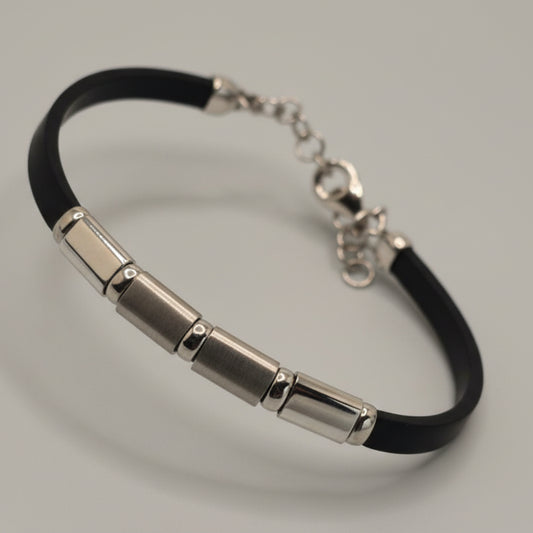 Silver bracelet with black strap on a light blue fabric background