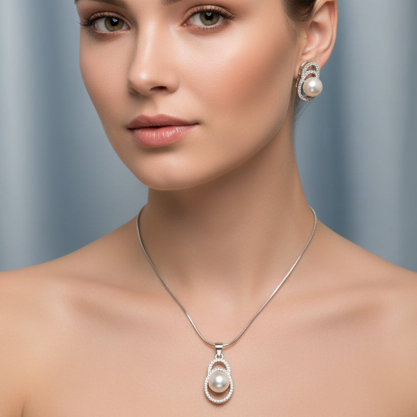 Pearl jewelry set with necklace and earrings on a light blue fabric background