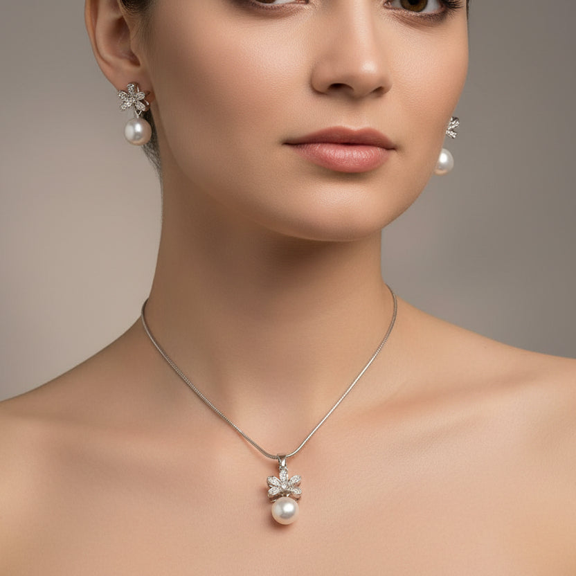 Pearl necklace with matching earrings on a light blue fabric background