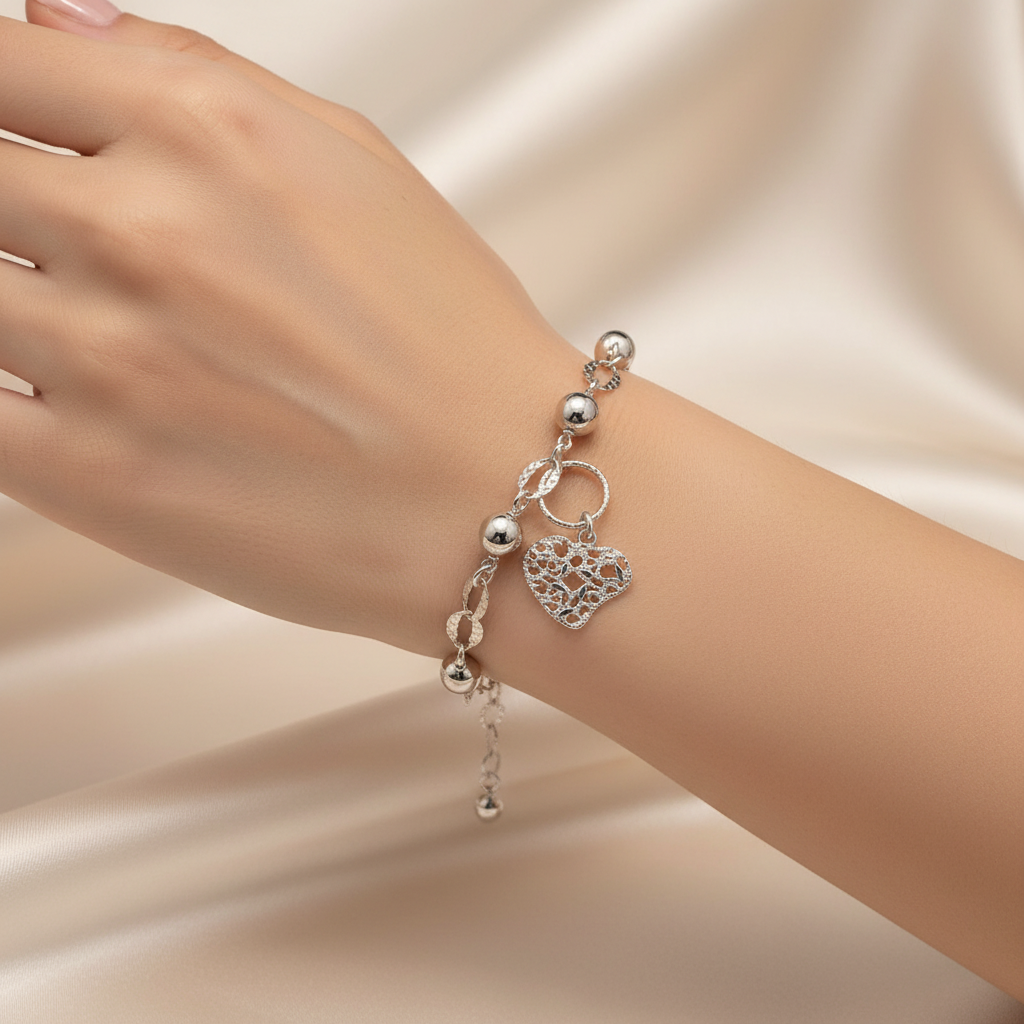 Silver bracelet with a heart-shaped charm on a light blue background