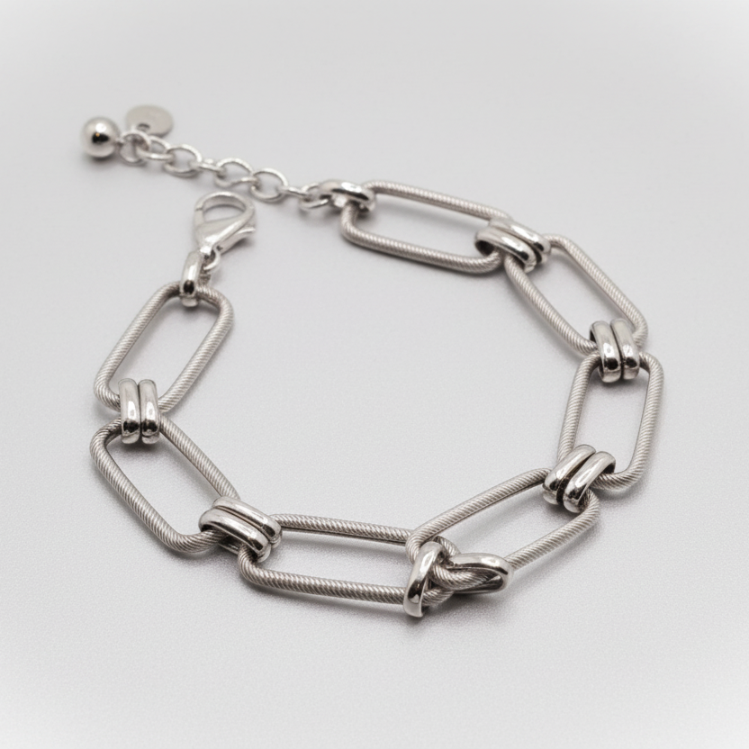 Silver chain bracelet on a light blue fabric background