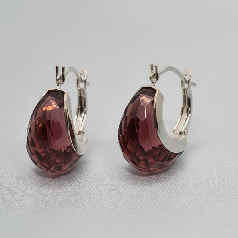 Pair of brown earrings with silver hooks on a gray background