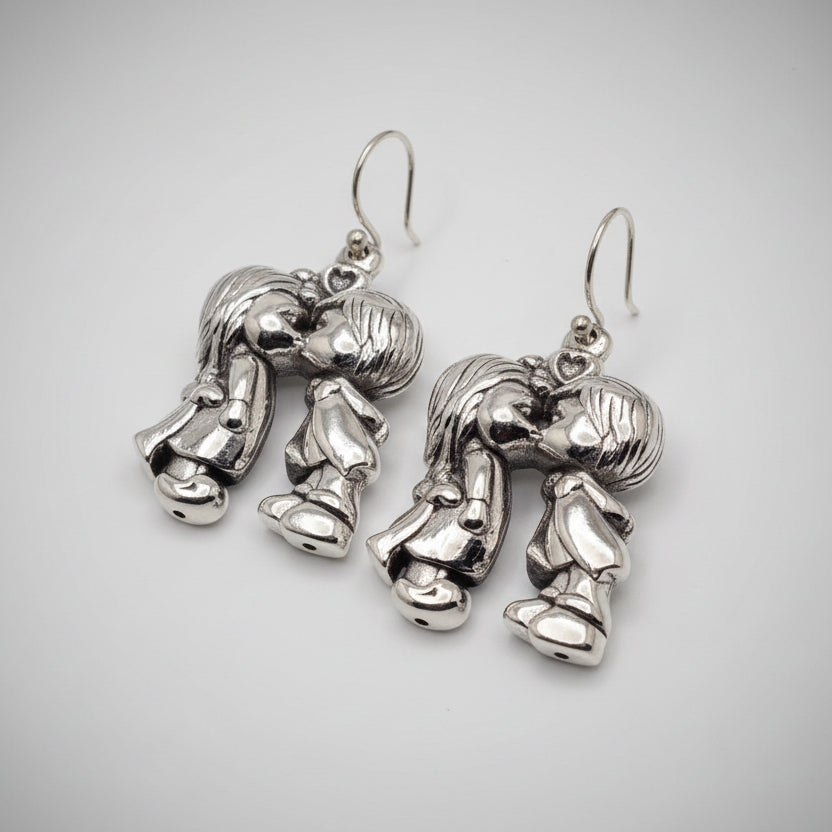 Silver robot-shaped earrings on a gray background