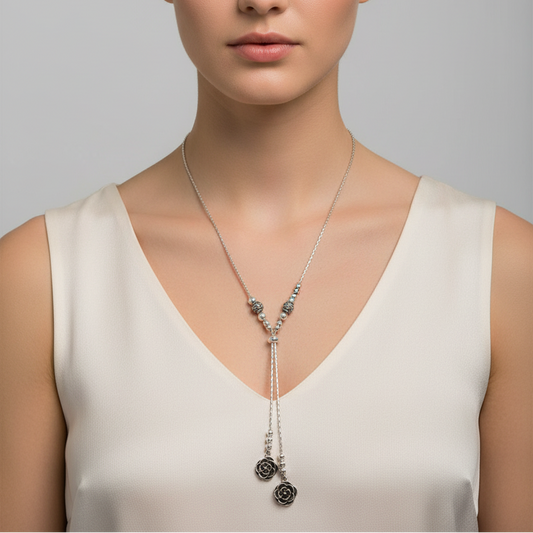 Silver necklace with floral pendants on a light gray fabric background