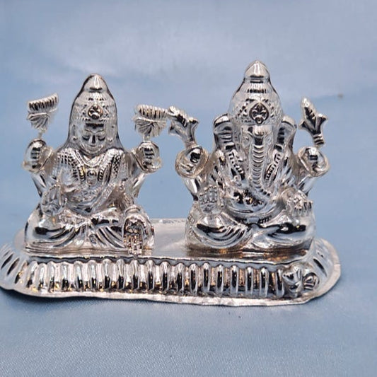 Silver deity figurine on a blue cushion